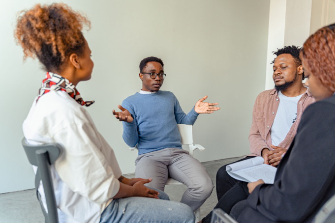 Diverse therapy group participants receiving culturally responsive mental health support